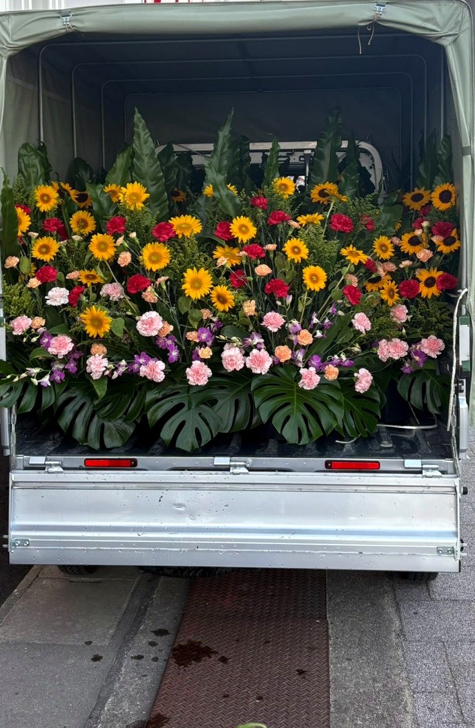 スタンド花を車両へ積み込み搬入する様子
